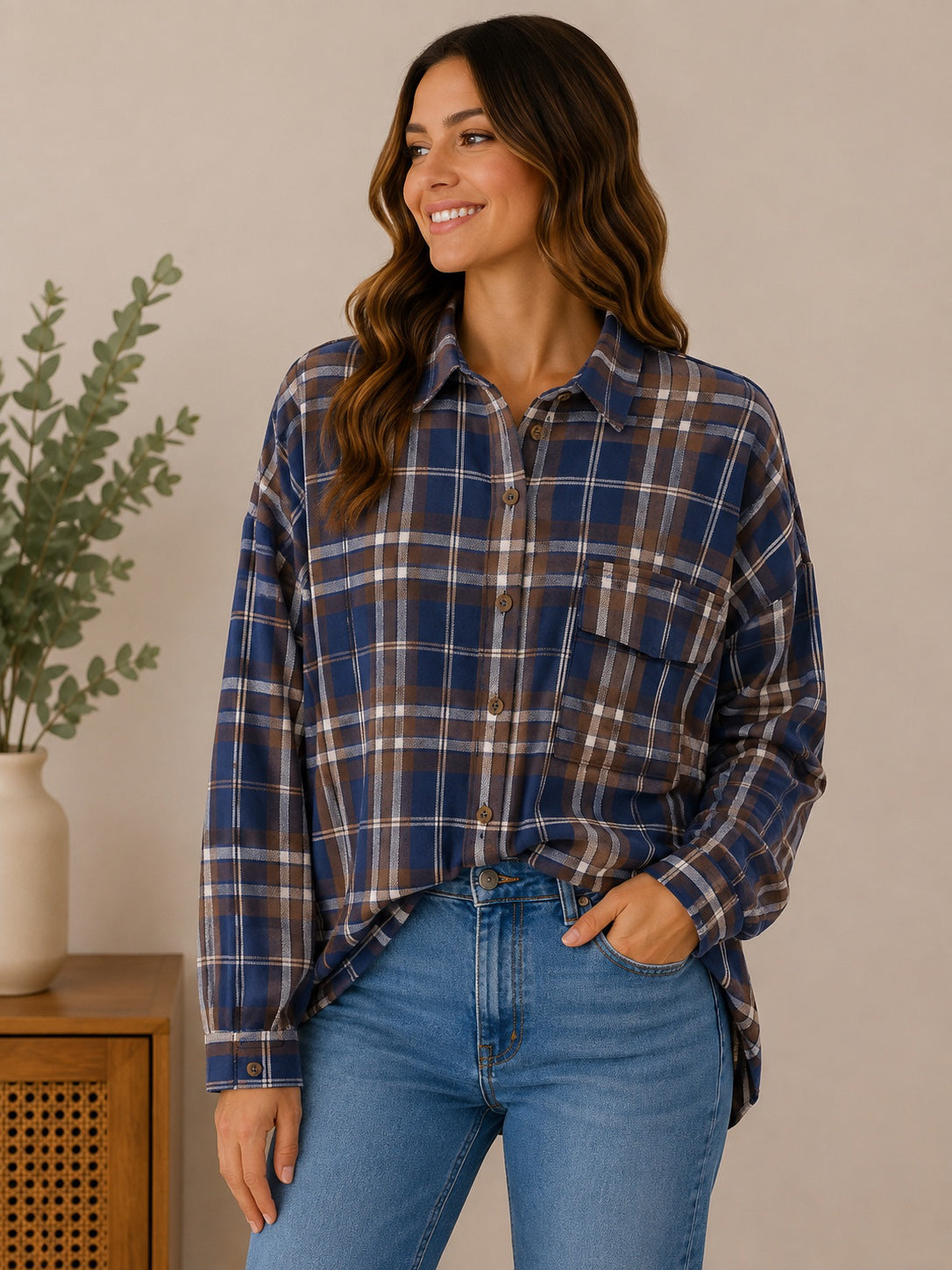 Woman wearing the fireside plaid button-up shirt in navy / brown / cream plaid.
